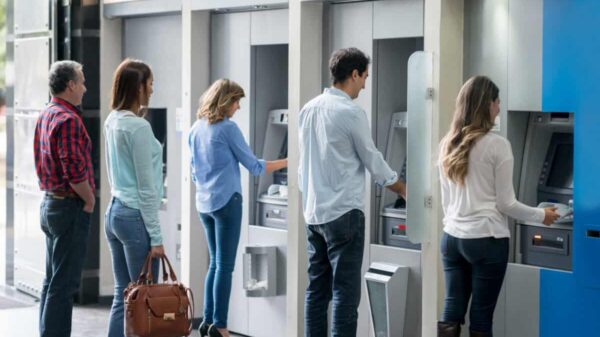 Group of people in a line at an ATM waiting to make a cash withdrawal